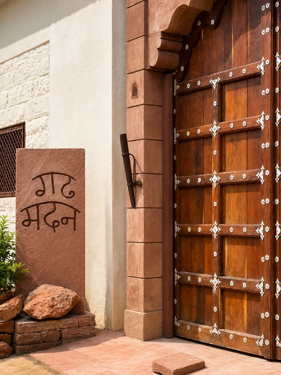Carved stone Garh Madan sign beside the wooden entrance door