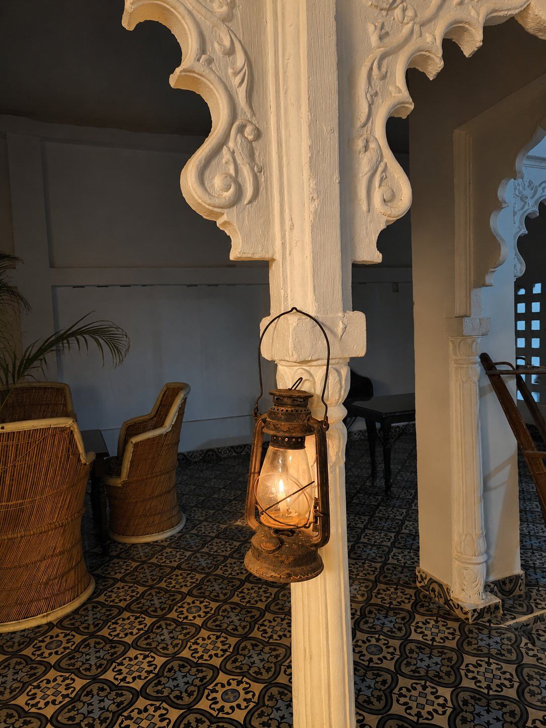 Brass lantern on a carved white pillar